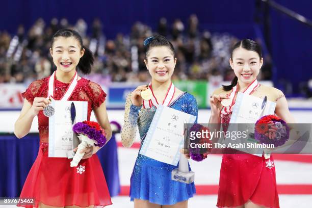 Silver medalist Kaori Sakamoto, gold medalist Satoko Miyahara and bronze medalist Rika Kihira pose on the podium at the medal ceremony for the ladies...