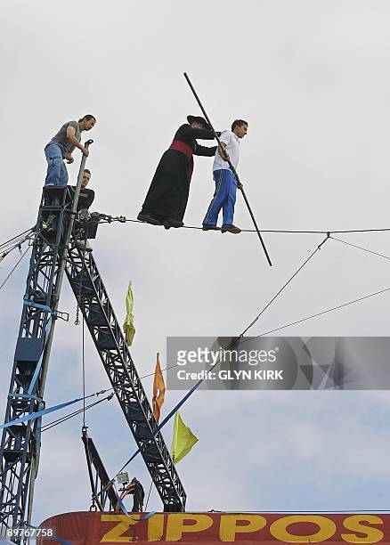 Chico Marinhos, a high wire walker, is followed by local priest Father Jerome Lloyd, as they walk across a wire suspended 80 feet above the ground,...