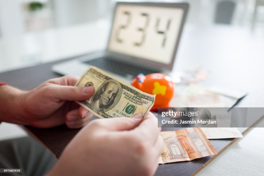 Hands counting different world currencies