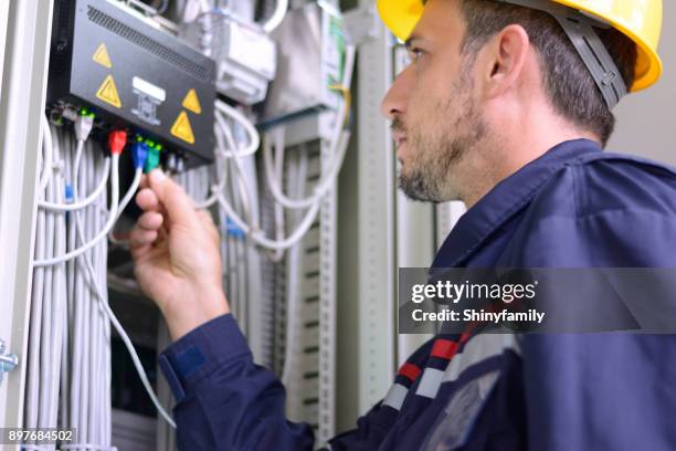 electrician connecting cable to the switch - fiber optics stock pictures, royalty-free photos & images