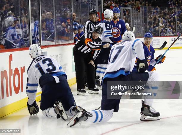 Referee Kelly Sutherland makes the first period tripping penalty call while laughing against Brandon Tanev of the Winnipeg Jets during the game...