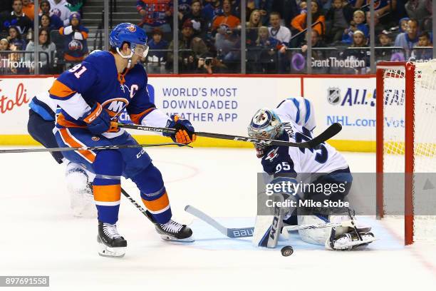 Steve Mason of the Winnipeg Jets makes a pad save against John Tavares of the New York Islanders at Barclays Center on December 23, 2017 in New York...