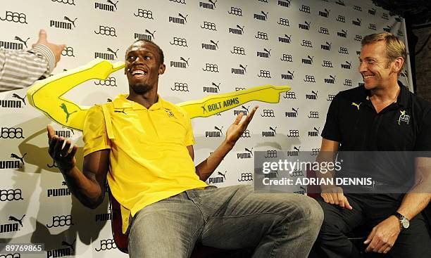 Double-Olympic sprint champion Usain Bolt of Jamaica gestures while wearing "Bolt Arms" during a press conference with Jochen Zeitz , CEO and...