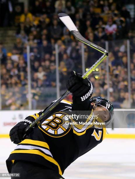 Torey Krug of the Boston Bruins breaks his stick while taking a shot against the Detroit Red Wings during the first period at TD Garden on December...