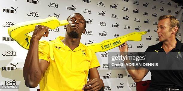 Double-Olympic sprint champion Usain Bolt of Jamaica pokes himself in the eye while gesturing with his "Bolt Arms" during a press conference with...