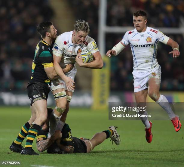 Jonny Hill of Exeter is held by Rob Horne and Teimana Harrison during the Aviva Premiership match between Northampton Saints and Exeter Chiefs at...