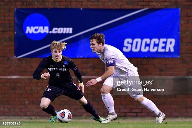 Colby Thomas of Messiah College dribbles the ball past Kyle Robson of North Park University during the Division III Men's Soccer Championship held at...