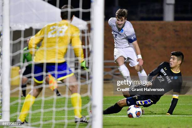 Colby Thomas of Messiah College shoots the ball past defender Ricky Pimentel of North Park University during the Division III Men's Soccer...