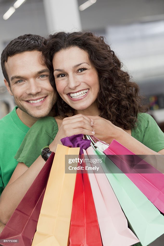 Couple shopping holding up shopping bags