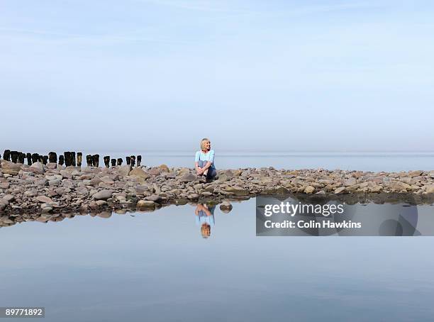 mature woman sitting on beach - porlock fotografías e imágenes de stock