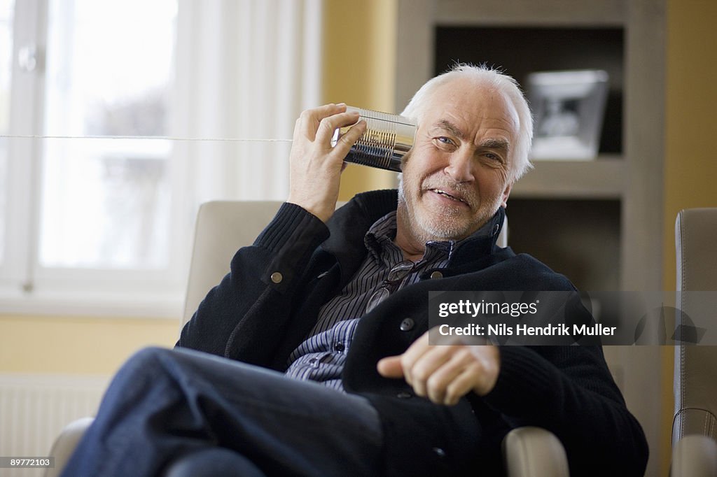 Old man playing with can phone