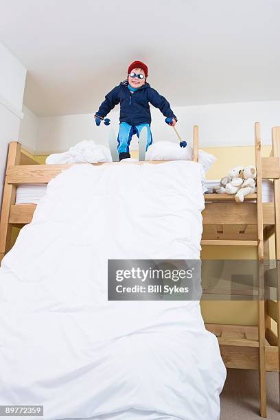 boy with skis on bed - crazy kid stock pictures, royalty-free photos & images
