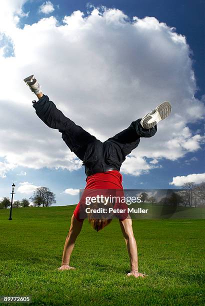 man performing handstand in park - boy handstand stock pictures, royalty-free photos & images