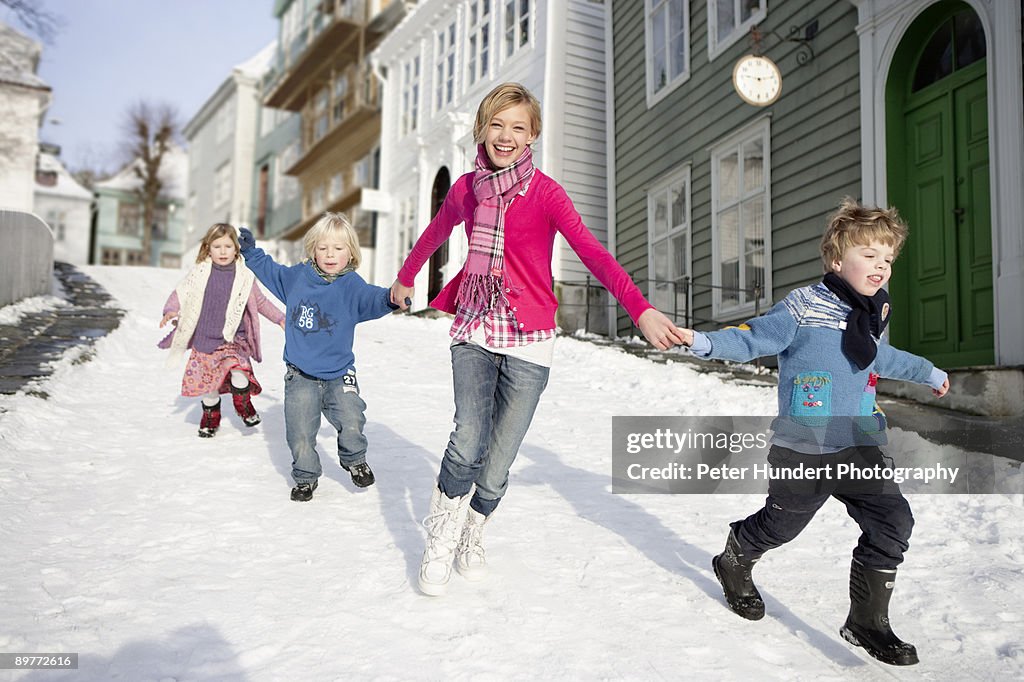 Scandinavian children running in snow