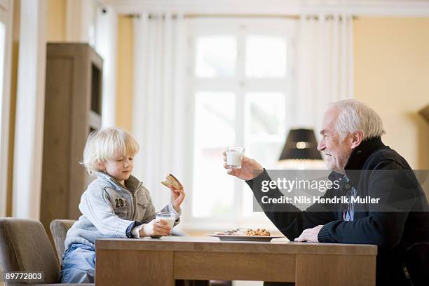 grandson and grandfather eating - child eat side photos et images de collection