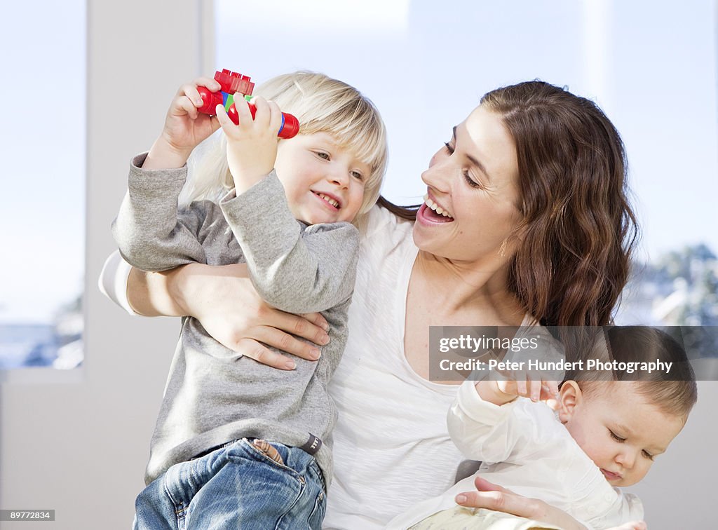 Mother and children cuddling and playing