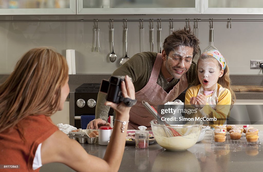 Mother taking picture of cooking family