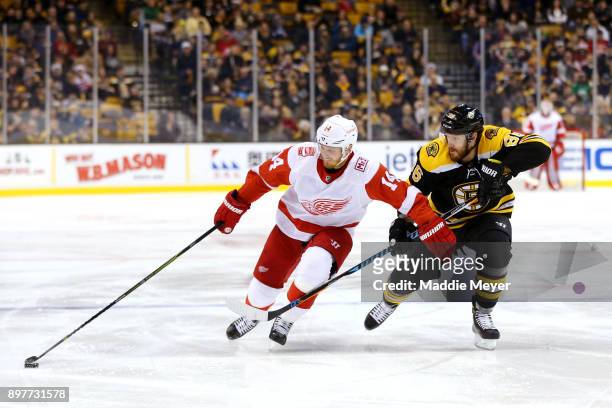 Kevan Miller of the Boston Bruins defends Gustav Nyquist of the Detroit Red Wings during the second period at TD Garden on December 23, 2017 in...