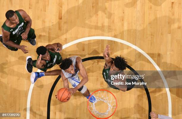 Jamal Johnson of the Memphis Tigers drives to the basket against Kavaughn Scott and Andre Walker of the Loyola-Maryland Greyhounds on December 23,...