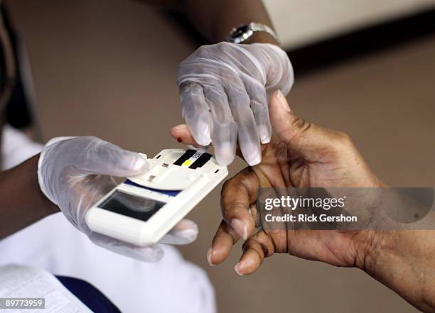 Mans finger is pricked to test his cholesterol at the City of Newark's free homeless health fair at the Department of Child and Family Well-Being on...