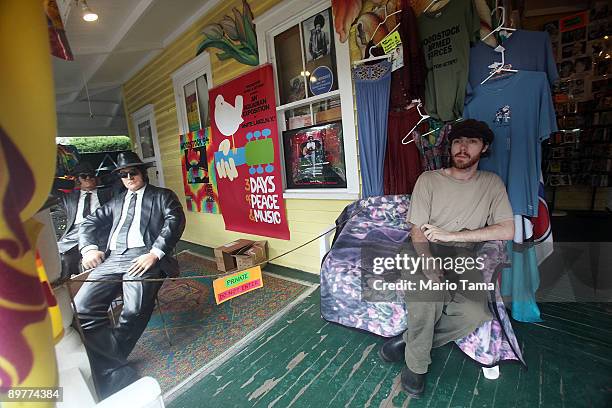 Man sits outside a souvenir shop as the 40th anniversary of the Woodstock music festival approaches August 13, 2009 in Woodstock, New York. On August...