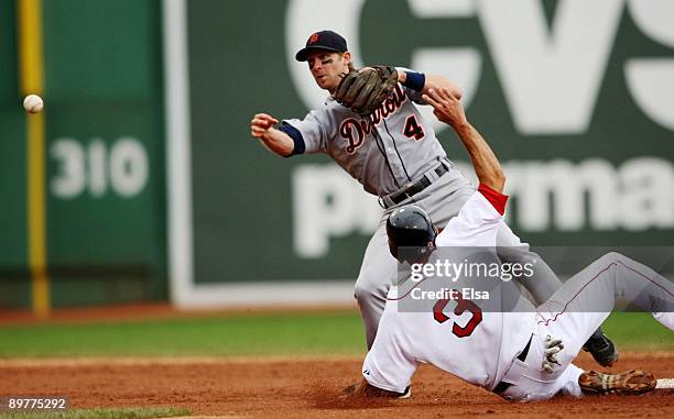 Adam Everett of the Detroit Tigers tries to make a double play tagging out Chris Woodward of the Boston Red Sox during the game at Fenway Park on...