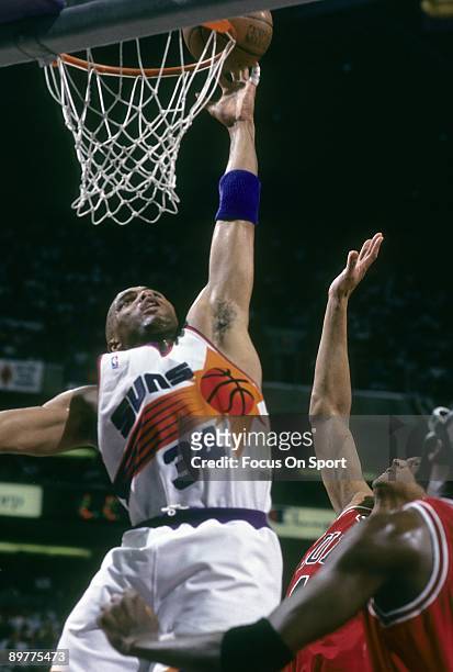 S: Charles Barkley of the Phoenix Suns in action tips the ball in in front of two Chicago Bull defenders during a early circa 1990's NBA basketball...