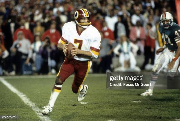 Quarterback Joe Theismann of the Washington Redskins in action rolls out with the ball against the Miami Dolphins during Super Bowl XVII on January...