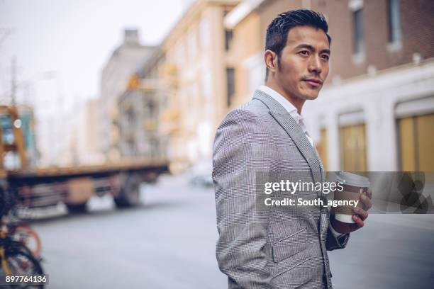 geschäftsmann mit kaffeetasse im freien - handsome man stock-fotos und bilder