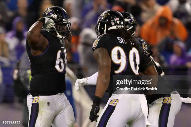 Defensive Tackle Willie Henry and defensive end Za'Darius Smith of the Baltimore Ravens celebrate after a sack in the second quarter against the...