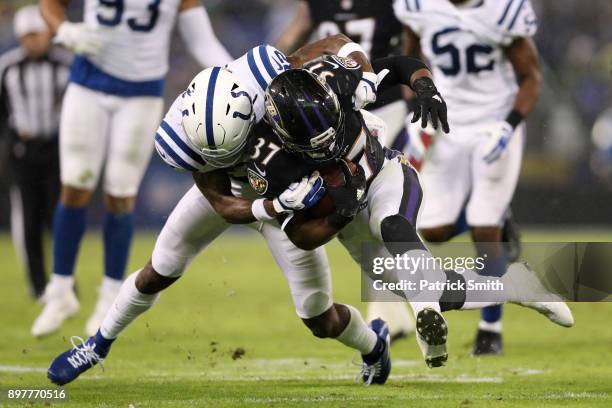 Running Back Javorius Allen of the Baltimore Ravens carries the ball as he is tackled by free safety T.J. Green of the Indianapolis Colts in the...