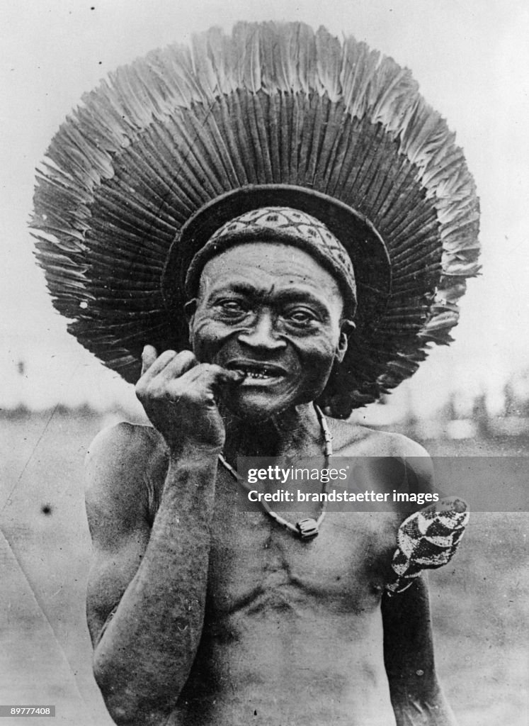 An African man with a traditional feather headdress. South Africa. Photograph. Around 1935.