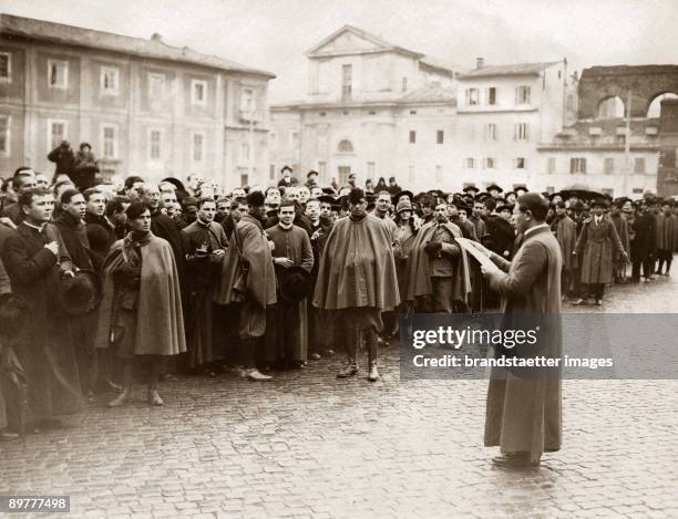 In front of the Lateran Palace in Rome, great crowds witness the arrival of the Papal Secretary of State, Pietro Gasparri, and Benito Mussolini for...
