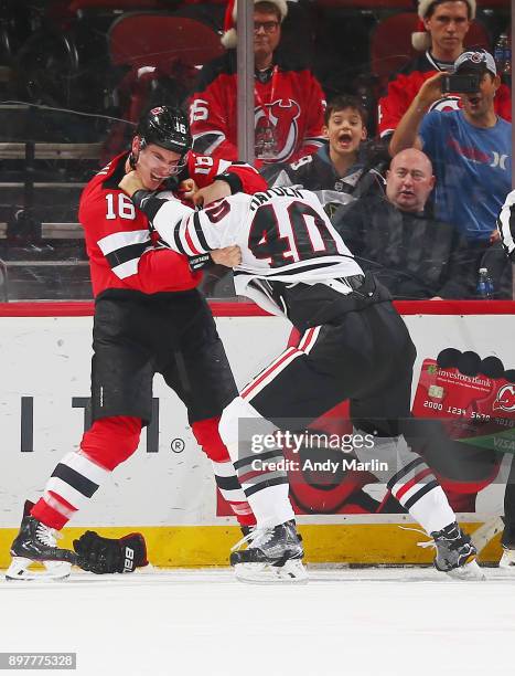 Steven Santini of the New Jersey Devils and John Hayden of the Chicago Blackhawks fight during the game at Prudential Center on December 23, 2017 in...