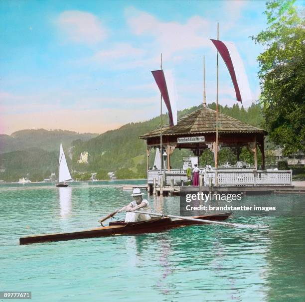 Rower at Lake Woerthersee. In the background band stand Werzer. Carinthia, Poertschach. Handcolored lantern slide. Around 1910.