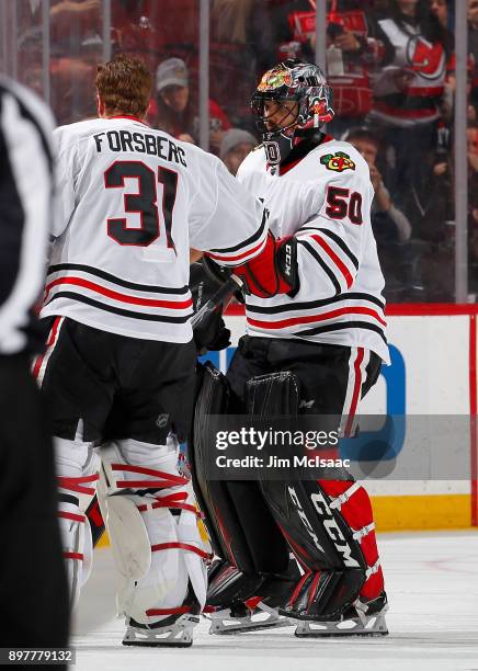 Corey Crawford of the Chicago Blackhawks is replaced in the first period against the New Jersey Devils by teammate Anton Forsberg on December 23,...