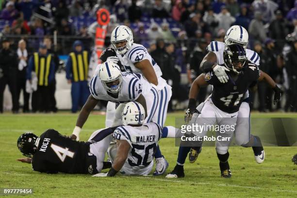 Punter Sam Koch of the Baltimore Ravens is knocked down during a blocked punt in the fourth quarter against the Indianapolis Colts at M&T Bank...