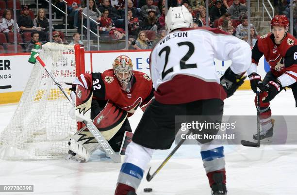 Goalie Antti Raanta of the Arizona Coyotes watches the puck as Colin Wilson of the Colorado Avalanche skates in during the first period at Gila River...