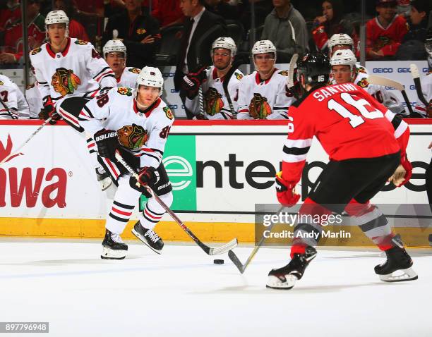 Patrick Kane of the Chicago Blackhawks plays the puck while being defended by Steven Santini of the New Jersey Devils during the game at Prudential...