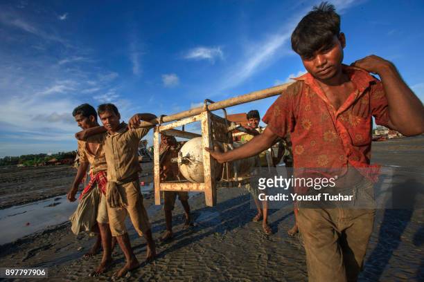 Ship breaking laborers carrying a gas tank at Sitakundo ship breaking yard. The ship breaking industry at Sitakundo started its operation in 1960.Due...