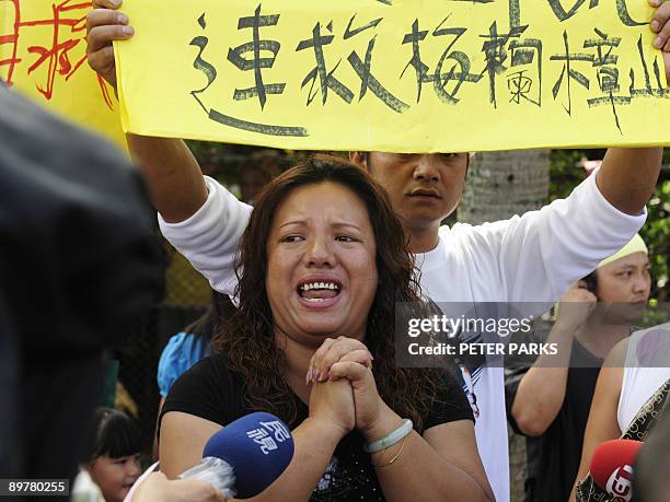 Woman reacts as she attends a rally demanding rescue teams take immediate action to evacuate relatives from the mountainous Meilanchang area, at...