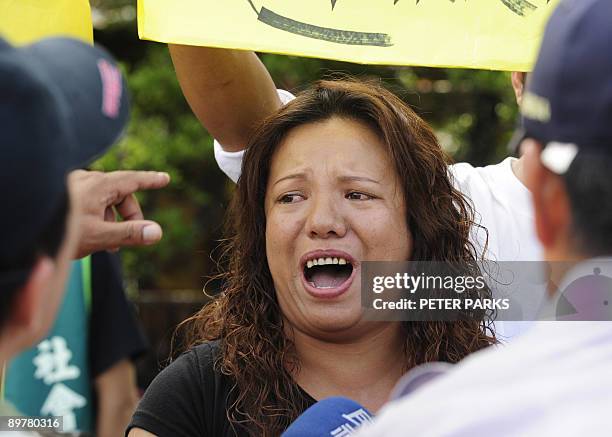 Woman reacts as she attends a rally demanding rescue teams take immediate action to evacuate relatives from the mountainous Meilanchang area, at...