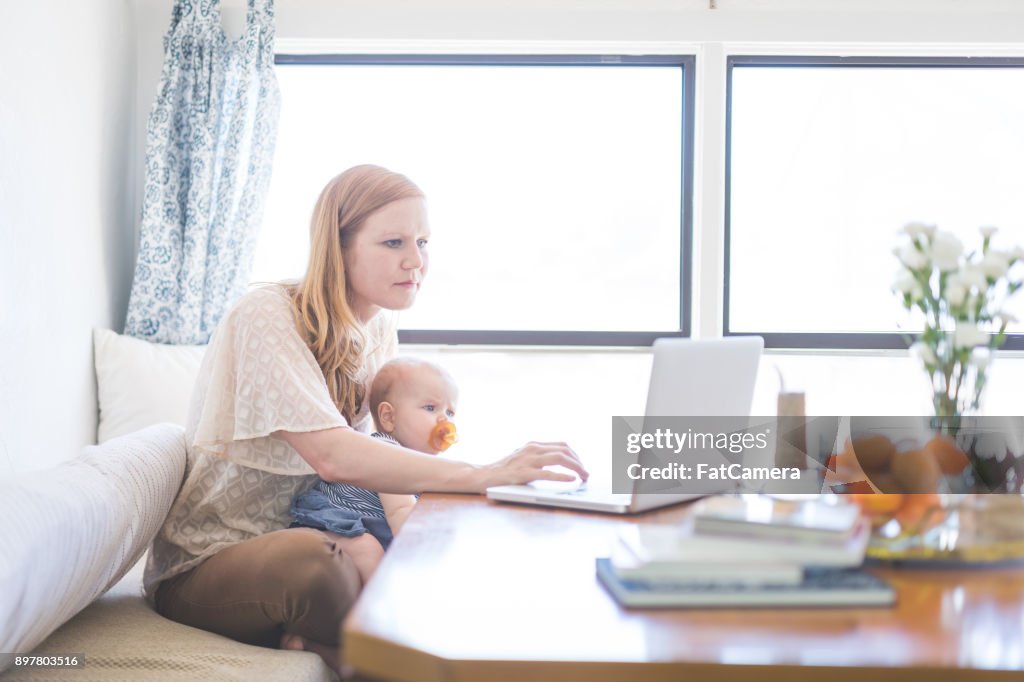 Mama Arbeitet Auf Ihrem Computer Ihr Säugling Baby Auf Dem Schoß Halten