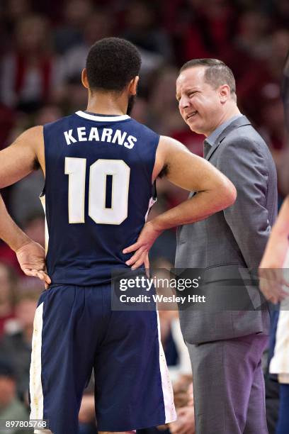 Head Coach Paul Mills talks with Sam Kearns of the Oral Roberts Golden Eagles dribbles during a game against the Arkansas Razorbacks at Bud Walton...