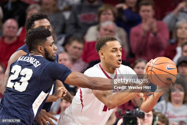 Daniel Gafford of the Arkansas Razorbacks is fouled making a pass by Emmanuel Nzekwesi of the Oral Roberts Golden Eagles at Bud Walton Arena on...