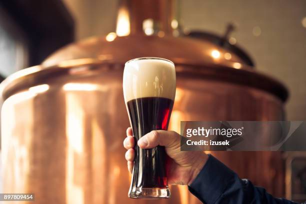 brewer holding glass of bitter ale beer at brewery - vat stock pictures, royalty-free photos & images