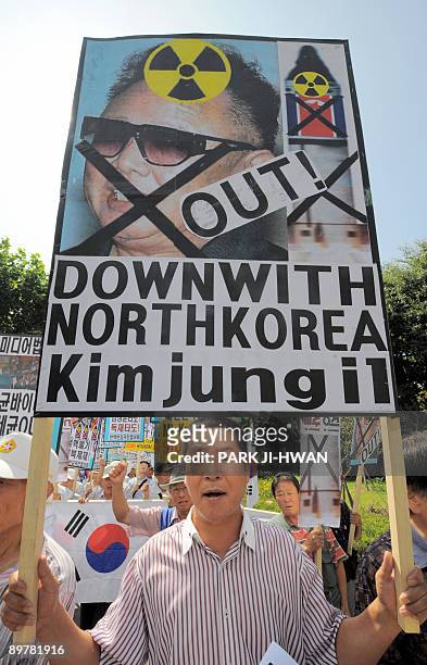 South Korean conservative activist holds a placard showing a picture of North Korean leader Kim Jong-Il during an anti-North Korea rally in Seoul on...