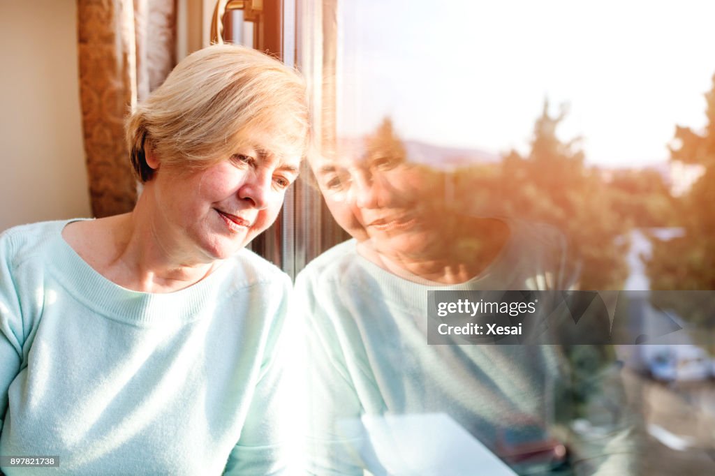 Alone woman day dreaming by the window