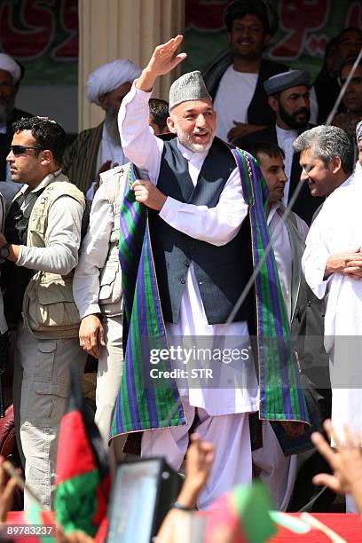Afghan President Hamid Karzai waves whilst campaigning for the upcoming August 20 presidential elections in Herat on August 14, 2009. Presidential...