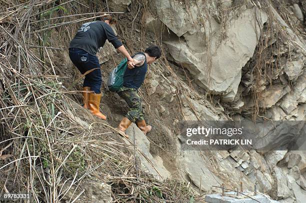 Rescurers climbs on the rocks along the river at the village of Meishan in Chiayi county, southern Taiwan, on August 14, 2009. Rescuers in Taiwan on...